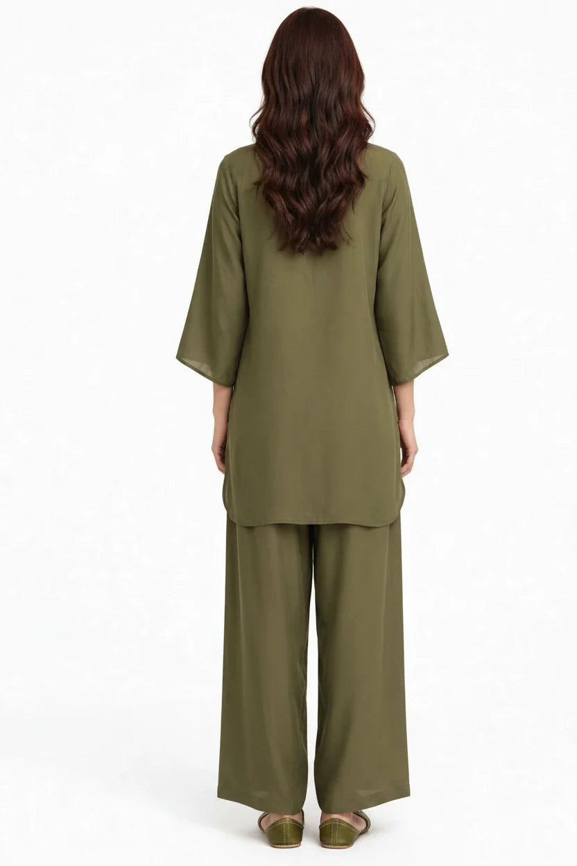 A woman viewed from the back wearing an olive green two-piece outfit consisting of a loose short-sleeve top and matching wide-leg pants, against a plain white background.