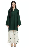 A woman modeling a dark green long-sleeve tunic with a split neckline, paired with off-white wide-leg pants featuring a green heart pattern, against a plain white background.